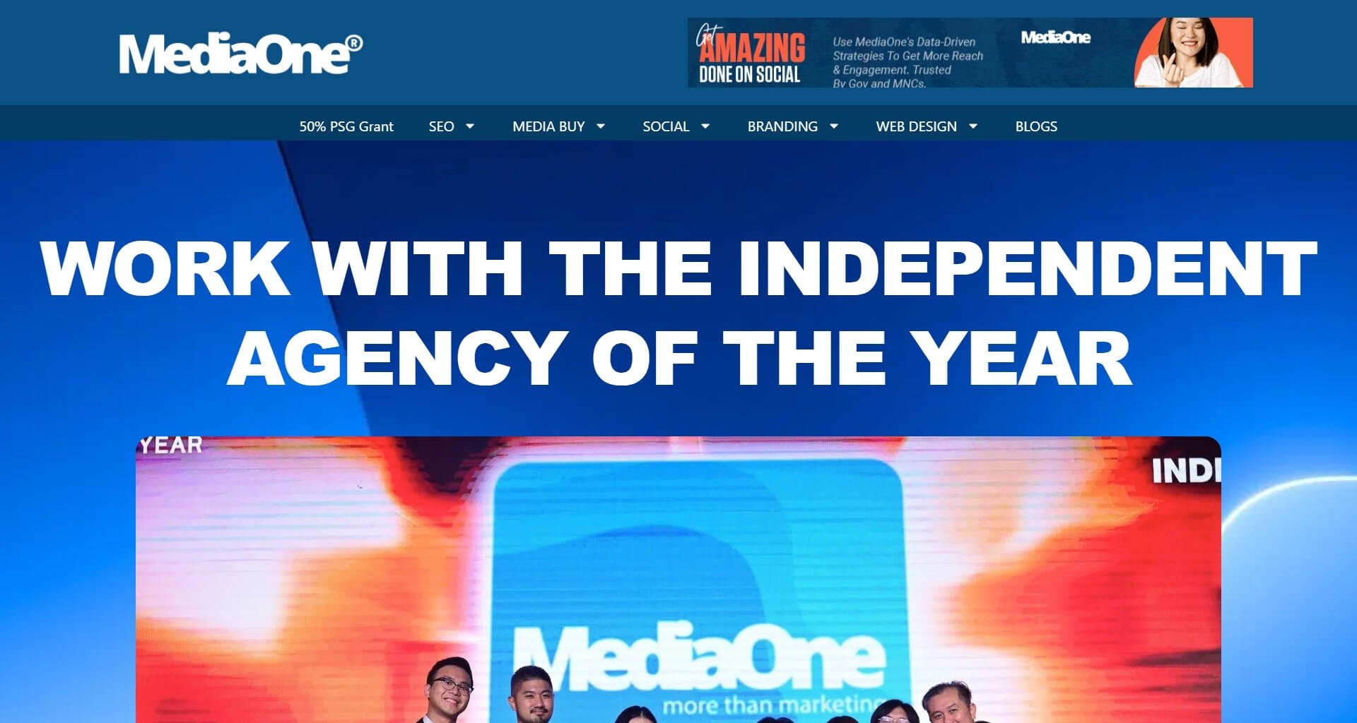 MediaOne homepage banner with a close-up photo of their team holding an award. The headline reads: