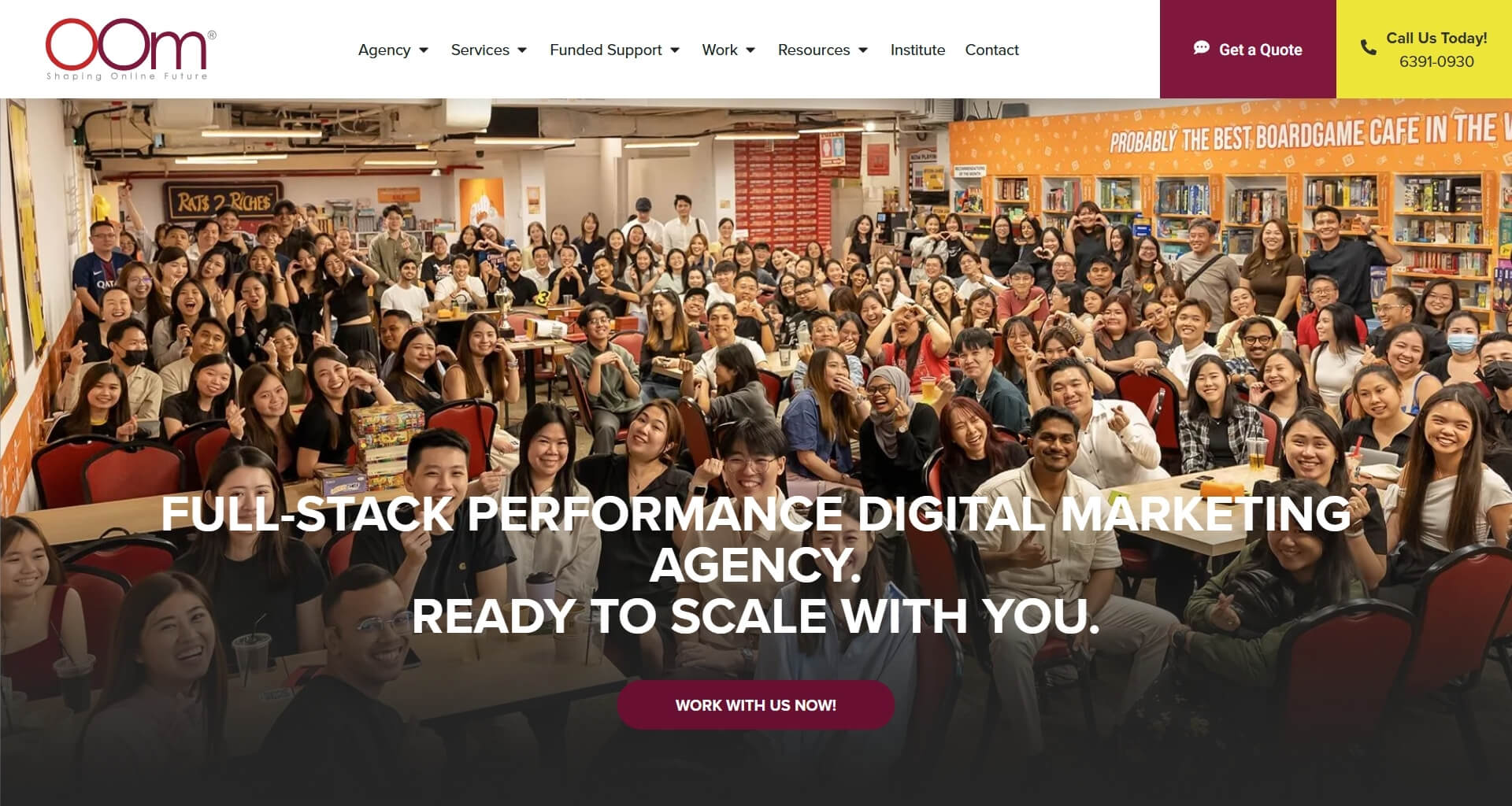 A large, diverse group of people from the OOM (Outrank Online Marketing) digital marketing agency gathered together in a brightly lit, casual office space, smiling and laughing. Overlayed text reads: