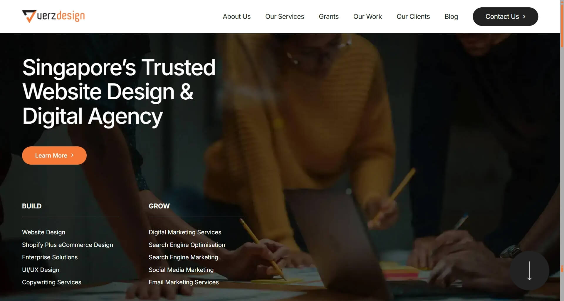 Verzdesign homepage banner showing three team members collaboratively working over a table, with pencils and papers visible. The headline states: